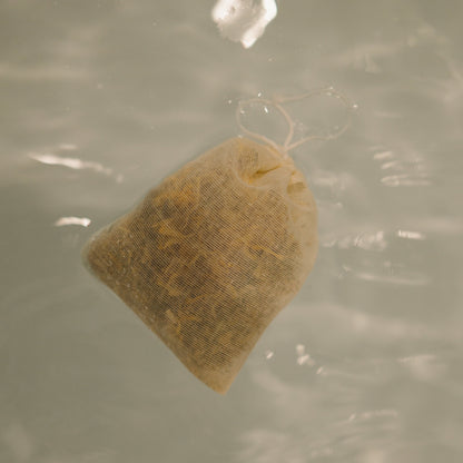 The postpartum herbal sitz bath by Honeybee Hippie features a small mesh bag of herbs that floats and infuses water, creating soothing ripples. It's an ideal perineal healing aid for postpartum moms.