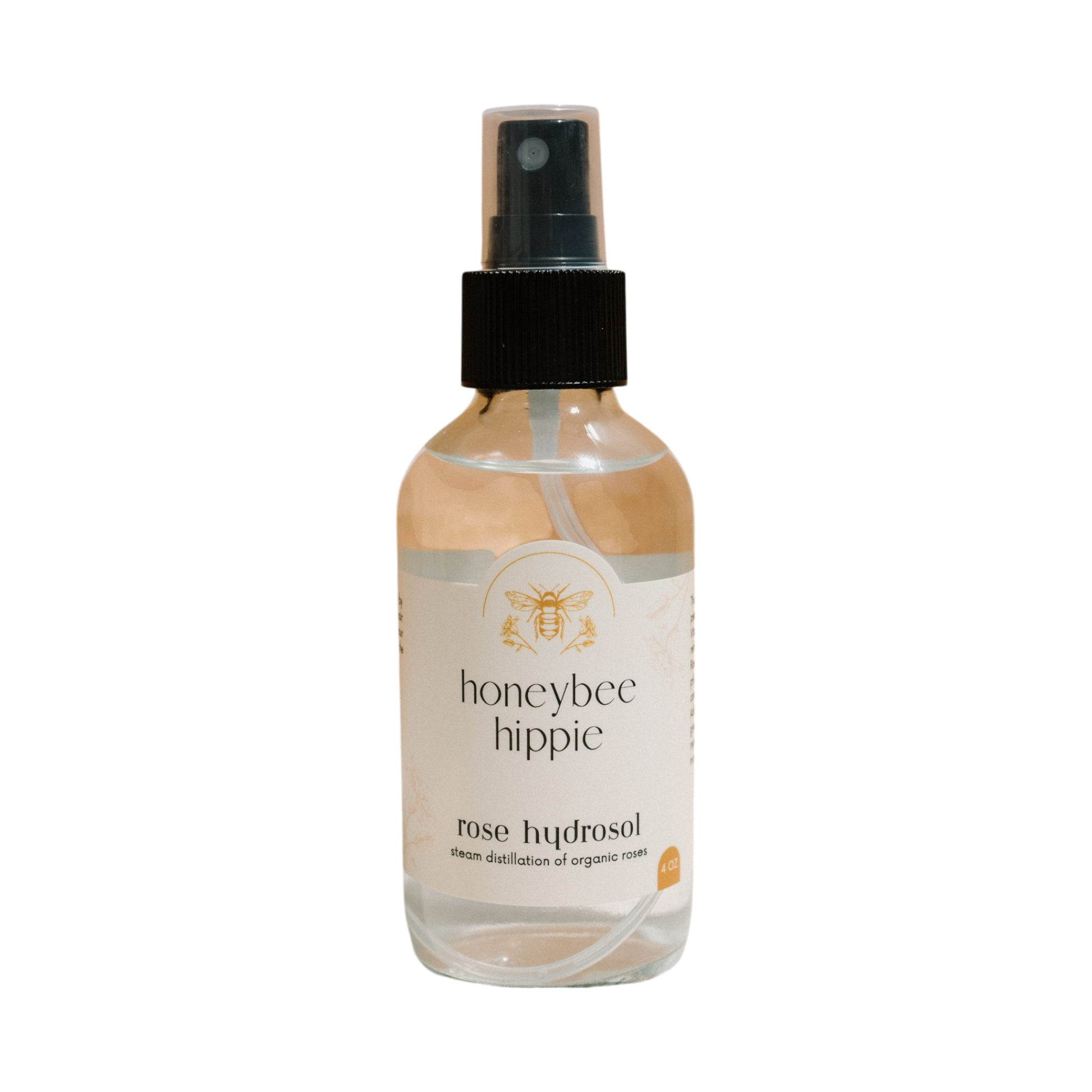 Honeybee Hippie's rose hydrosol is presented in a clear spray bottle with a black nozzle and bee logo. Steam distilled from organic roses, it's your ideal pores cleanser and moisture booster in one elegant spritz.