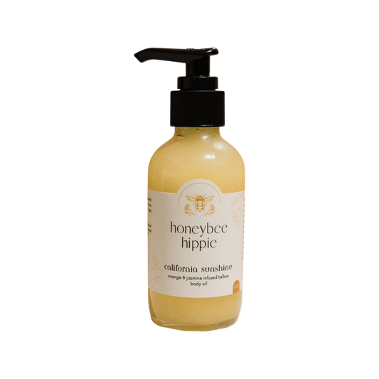 Honeybee Hippie's "California Sunshine" tallow oil features a pump dispenser and decorative bee logo; it's infused with organic orange peel and jasmine, containing a vibrant yellow, non-comedogenic liquid.