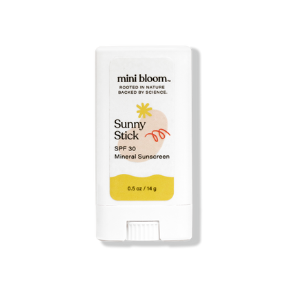 A white stick container of Sunny Stick Mineral Sunscreen by mini bloom, labeled as SPF 30 for babies. The packaging features a small sun illustration and has a net weight of 0.5 oz (14 g). The top reads, "Rooted in Nature, Backed by Science.