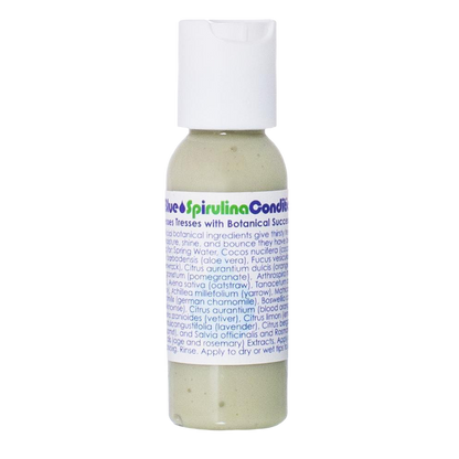 A small, transparent bottle of Living Libations' True Blue Spirulina Conditioner, designed for dry hair and enriched with azulene essential oils, contains a greenish-tinted liquid. The bottle features a white flip-top cap and a label that lists the ingredients and usage instructions, both adorned with blue and green accents.