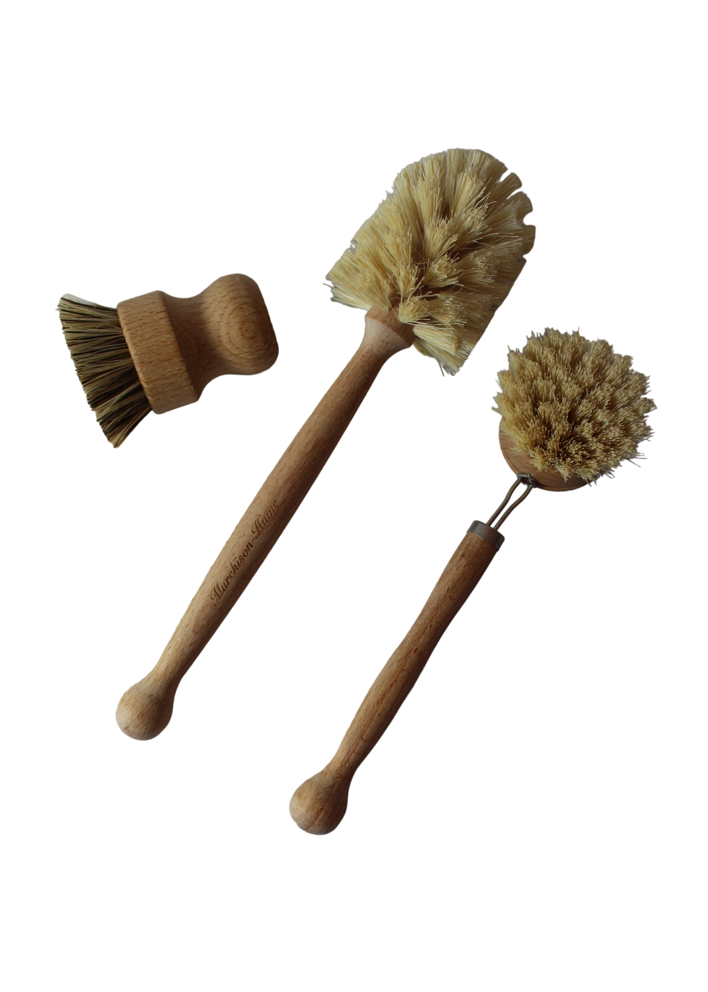 The All-Brush Bundle by Murchison-Hume is displayed on a white background, featuring three wooden cleaning brushes with natural fiber bristles. The set includes a short mushroom-shaped brush, a long-handled brush with an angled head, and a round brush with a slightly bent handle. These compostable brushes are ideal for eco-friendly cleaning.
