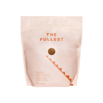 A light peach-colored, resealable bag with "THE FULLEST" written at the top in bold orange letters. Below, a gold circle leads to a staircase graphic. The bottom of the bag reads "Warm Feelings Bulk," indicating it is a caffeine-free saffron latte powder dietary supplement designed to improve mood.