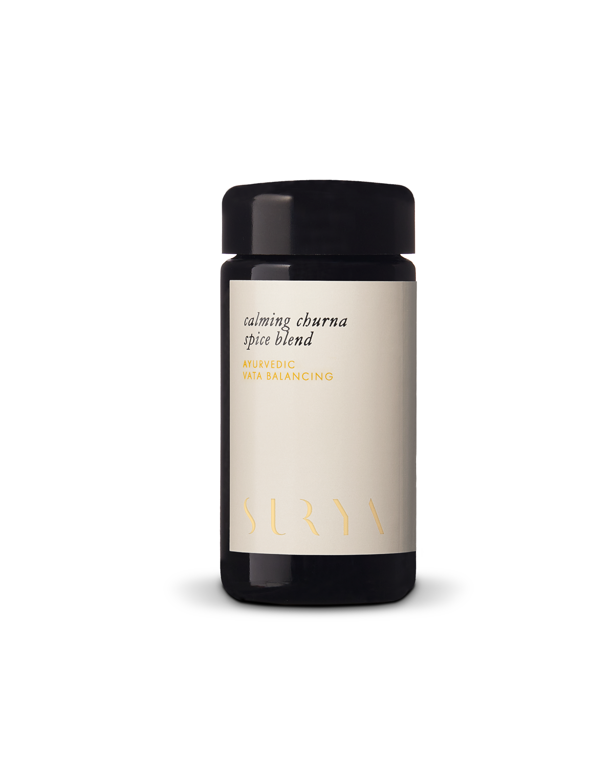 A black cylindrical container with a light beige label that reads "Calming Digestive Spice Blend" and "AYURVEDIC VATA BALANCING." Featuring organic ingredients, the brand name "Surya" is placed at the bottom of the label in a minimalist font. Perfect for cooking dahl.