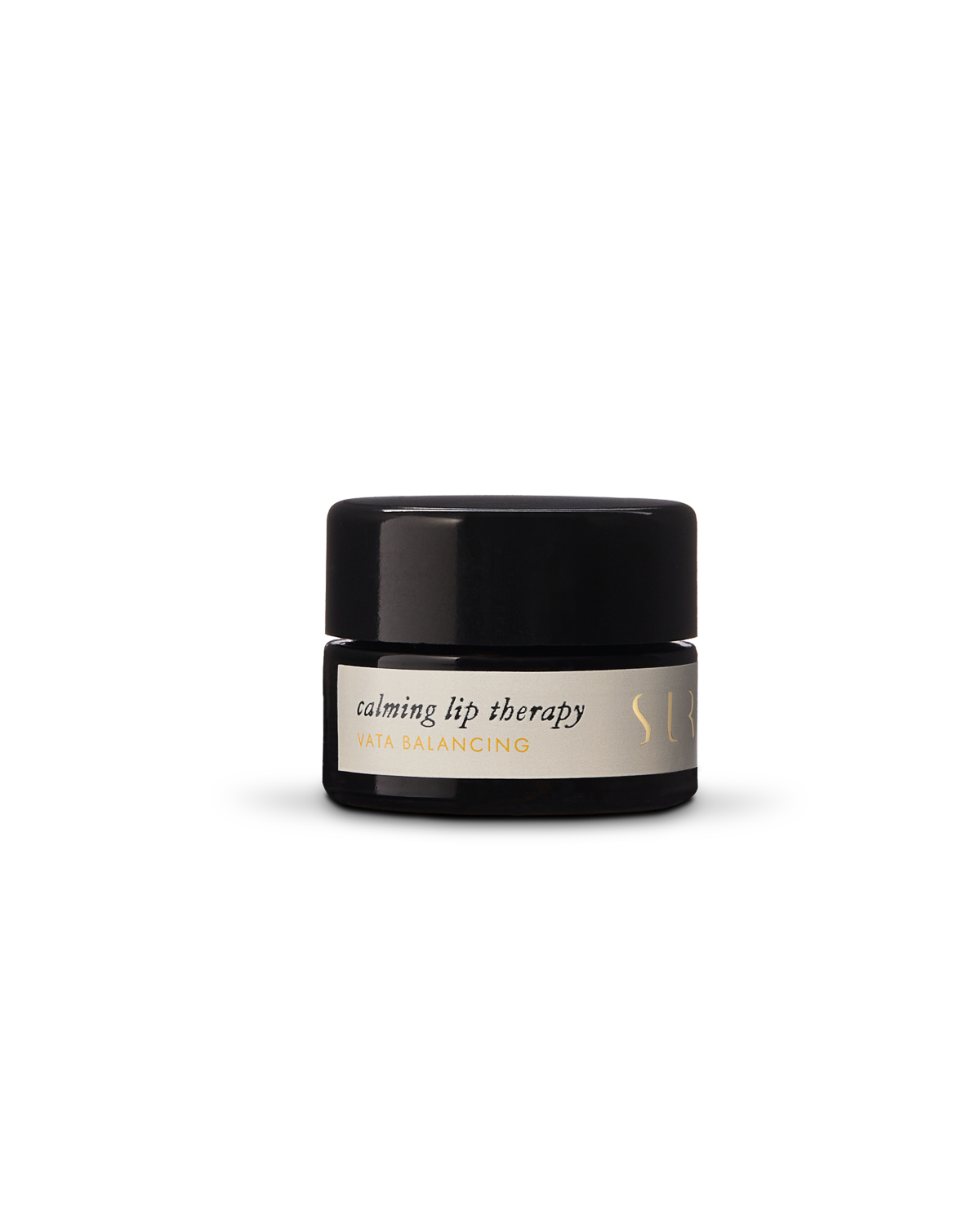 A small, opaque black jar with a screw-on lid contains Surya's "Calming Lip Therapy," subtitled "Vata Balancing." The container features a simple, minimalist design with gold accents. This moisturizing treatment boasts a creamy formula made from organic ingredients.