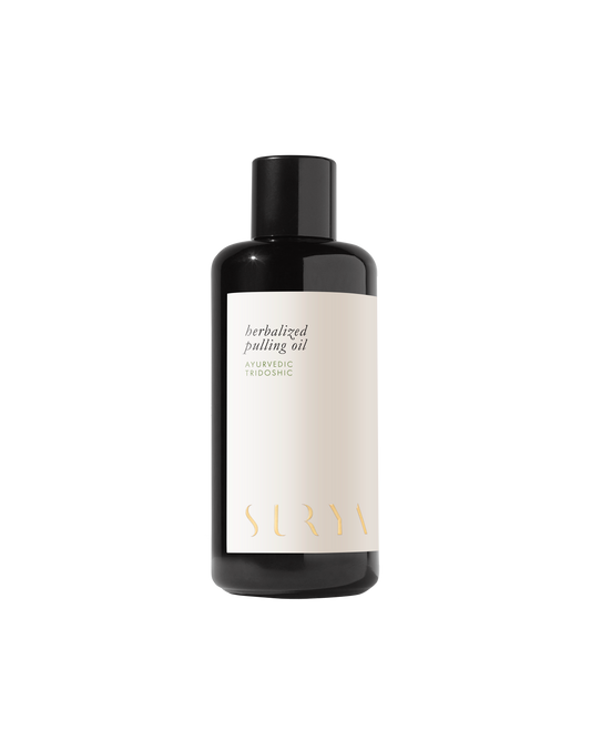 A dark-colored bottle with a black cap, labeled "Herbalized Pulling Oil." The minimalist design features clean lines with the word "Surya" written in a stylized font at the bottom of the label, emphasizing its roots in Ayurveda and traditional oil pulling practices.