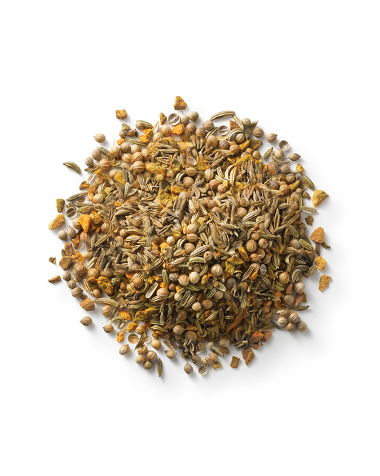 A close-up image of a pile of mixed spices, including fennel seeds, coriander seeds, and orange peel. The mixture appears varied in color, with light green and brown hues dominating the composition. It's perfect for creating Surya's Balancing Digestive Tea to reduce bloating.