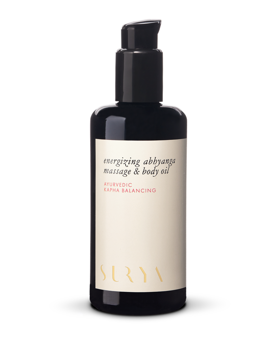 A black bottle with a pump dispenser labeled "Energizing Body Oil" and "Ayurvedic Kapha Balancing." The label also features subtle gold text displaying the brand name "Surya." Ideal for lymphatic self-massage, the bottle stands against a white background.