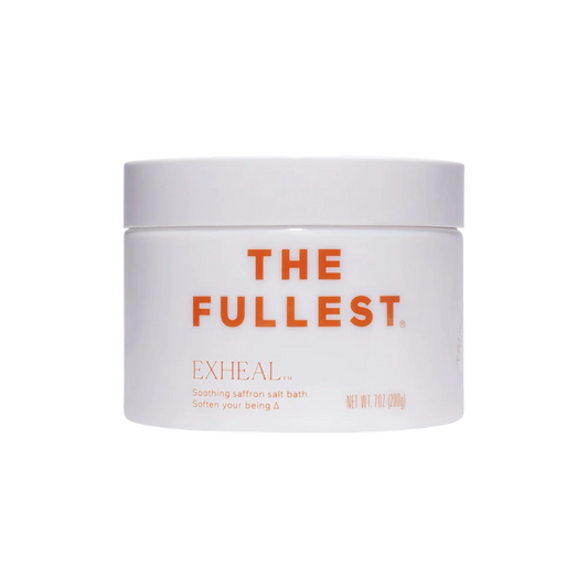 A white jar featuring the orange text "THE FULLEST" on the front, with "EXHEAL™ Soothing saffron salt bath for muscle relaxation and digestive support. Soften your being. Δ" written below it. The jar has a white lid and contains 200g of Exheal Salt Bath product.