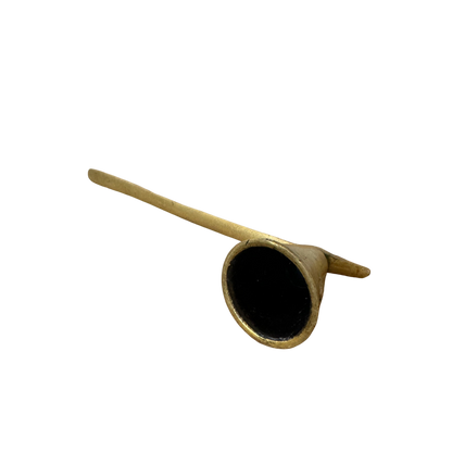 A classic Brass Candle Snuffer by Shoppe Maison, showcasing a sleek, tapered handle and an elegant yellow, funnel-like design with a narrow tube extending into a wider circular opening at one end. Set against a black background, the smooth texture highlights its darkened interior.