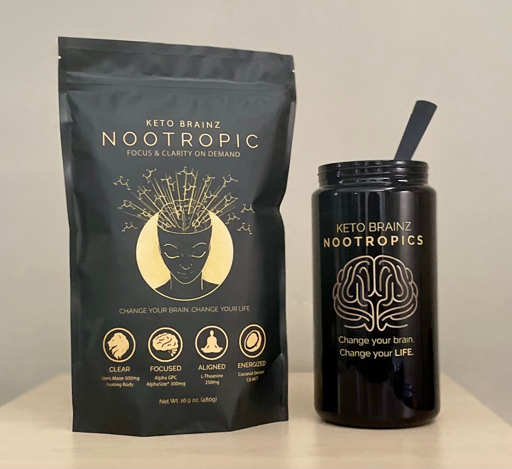 A sleek, black resealable bag labeled "Keto Brainz + Miron Glass Countertop Jar" sits beside a minimalist, black tumbler with a straw, both adorned with a brain graphic and the motto "Change your brain. Change your life." Perfect for those looking to optimize counter space in style.