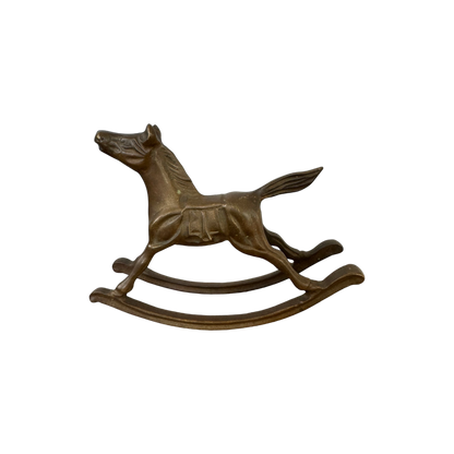 A bronze-colored mini Brass Rocking Horse sculpture from Shoppe Maison is pictured on a black background. The horse, depicted in mid-gallop with its front and hind legs extended, features a smoothly curved rocking base and boasts a vintage, classical design.