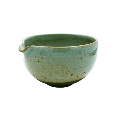 This small Katakuchi Matcha Tea Bowl from Chafinity Tea has a spout on one side and features a speckled ceramic texture. The surface showcases varying shades of green, with a darker base and a slightly uneven, handcrafted appearance. It's perfect for experiencing Japanese hospitality with Chafinity Tea.