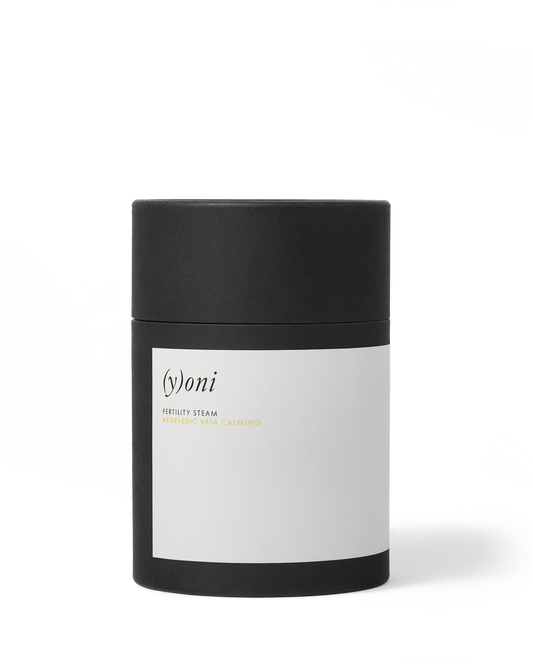 A cylindrical black container with a white label showcases the brand name "Surya" and describes the product as "(y)oni Fertility Steam" and "Ayurvedic Vata Calming." Perfect for pregnancy preparation, this blend of Ayurvedic herbs is encased in a sleek design with a matching black lid.