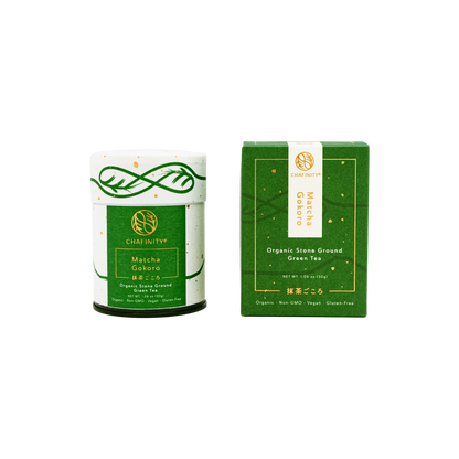 The image features a green cylindrical tin container of Chafinity Tea's Organic Stone Ground Ceremonial Matcha Gokoro, reminiscent of Japanese tea ceremonies. It is positioned next to its matching green rectangular box packaging, with both products adorned with gold and white text and branding elements.