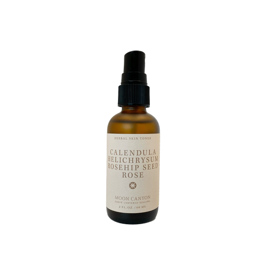 A brown glass bottle with a black pump dispenser labeled "Herbal Skin Toner" from Moon Canyon Healing features anti-inflammatory herbs such as Calendula, Helichrysum, and Rosehip Seed Rose. The 2 FL. OZ. / 60 ML bottle contains organic ingredients.