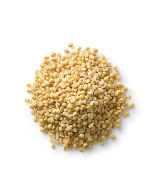 A close-up of a pile of Surya Mung Beans on a round, transparent plate against a white background. The high-protein mung beans are small, round, and uniformly colored, making them an easily digestible choice.