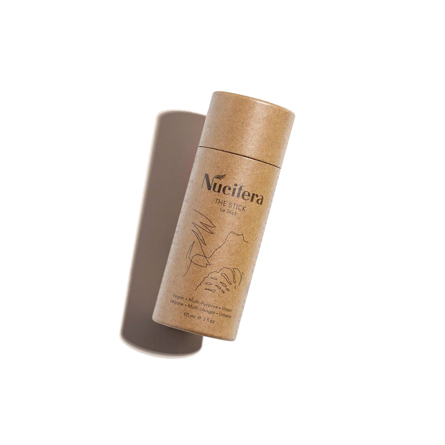 A cylindrical brown paper container labeled "Nucifera Body Store The Stick" stands upright on a plain white background. The minimalist packaging, designed for their multi-purpose balm, features subtle illustrations and text.