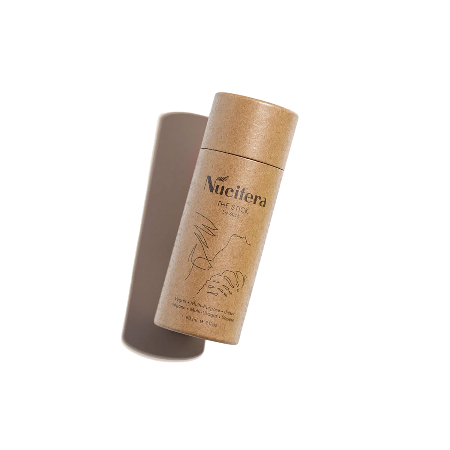 A cylindrical, eco-friendly cardboard container labeled "Nucifera The Stick" from Nucifera Body Store, featuring minimalist line art and holding a solid deodorant stick, is shown against a plain white background. As part of The Essentials Kit, this multi-purpose skincare product appears slightly angled with the lid propped open.