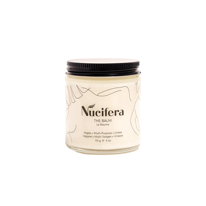 A jar of The Balm from Nucifera Body Store is shown against a white background. Designed to enhance skin tone and texture, this vegan and unisex product features a minimalist label with line art and a black lid. The container holds 113 grams (4 oz) of balm.