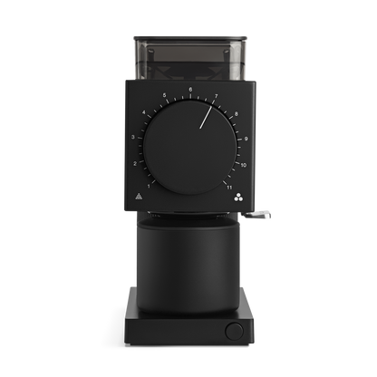 The Ode Brew Grinder by Fellow Wholesale is a modern black coffee grinder with a sleek cylindrical base and a rectangular top section featuring advanced anti-static technology. It offers 31 grind settings adjusted via a prominent circular dial numbered 1 through 11 and includes a convenient small lever on the side for additional adjustments. A transparent hopper at the top elegantly displays the beans inside.