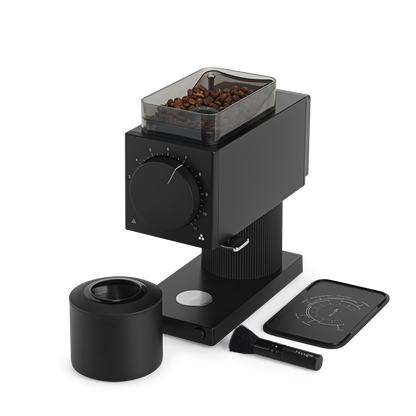 The Fellow Wholesale Ode Brew Grinder is a sleek black coffee grinder with a transparent container for holding coffee beans on top. It features Gen 2 Brew Burrs and offers 31 grind settings, complemented by a large dial on the front. The setup includes a brush, a cylindrical container for grounds, anti-static technology, and a digital scale with minimalist design accents.