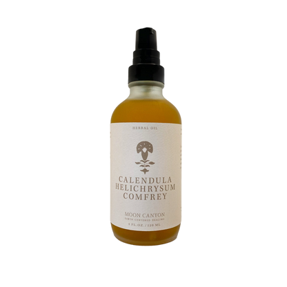 A 4 fl oz (120 ml) bottle of "Calendula, Helichrysum & Comfrey Herbal Oil" from Moon Canyon Healing. The bottle is equipped with a pump dispenser and features a beige label with minimalist design elements set against a black background.