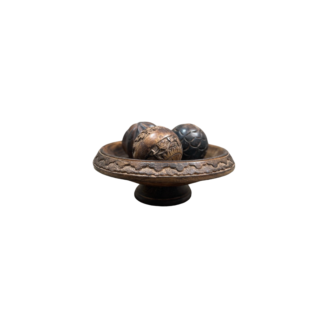 A vintage Carved Wood Pedestal from Shoppe Maison features three intricately designed balls, each boasting unique patterns and textures, set against a simple black background.