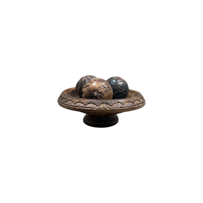 A vintage Carved Wood Pedestal from Shoppe Maison features three intricately designed balls, each boasting unique patterns and textures, set against a simple black background.