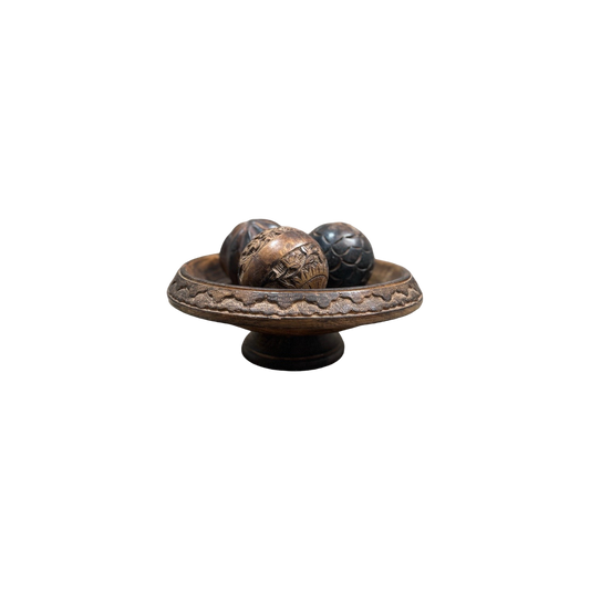 A vintage Carved Wood Pedestal from Shoppe Maison features three intricately designed balls, each boasting unique patterns and textures, set against a simple black background.