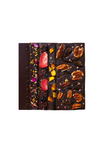 Discovery Collection chocolate bars by Spring & Mulberry are arranged vertically on a black background. Each date-sweetened bar is uniquely topped with various ingredients like nuts, dried fruits, and colorful garnishes, offering both deliciousness and nutritional value.