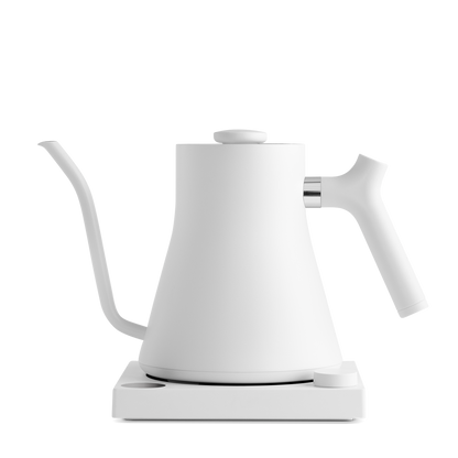 The Stagg EKG Electric Kettle from Fellow Wholesale is a sleek, modern white pour-over kettle featuring a precise gooseneck spout and an ergonomic handle, elegantly positioned on its base. This kettle boasts a minimalist design, variable temperature control, and a matte finish.