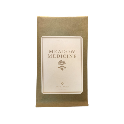 A brown paper pouch labeled "MEADOW MEDICINE TEA BLEND" in capital letters is pictured. The label features an illustration of a plant and the text "HERBAL TEA BLEND" above and "MOON CANYON HEALING" 