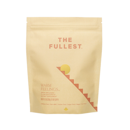 A pink/beige resealable pouch of THE FULLEST's "Warm Feelings® Saffron Latte - 30 Day Supply" dietary supplement features orange text. With a minimalist design that includes sun and staircase graphics, the product is designed to improve mood and promote restorative sleep. This non-GMO, gluten-free, sugar-free, vegan blend also offers a caffeine-free saffron latte mix.