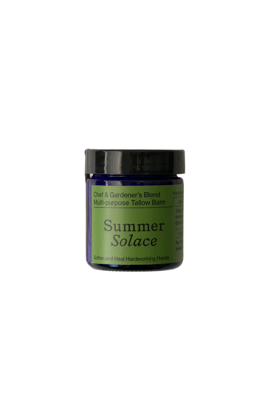 A small, dark violet jar with a black lid is labeled "Chef & Gardener's Balm - Regenerative Tallow™." The label also reads "Summer Solace Tallow" in green text, emphasizing its purpose to soften and heal hardworking hands through a therapeutic skin treatment featuring healing rosemary and helichrysum.