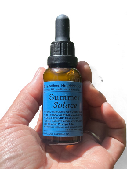 A hand holds a brown dropper bottle labeled "Summer Solace Tallow" with blue text. The label highlights the luxury skincare oil's non-GMO ingredients and benefits for skin health and appearance. Hand-poured in Oakland, CA, this Emanations Nourishing Face and Hair Oil-Animal-based is free from animal-based ingredients.