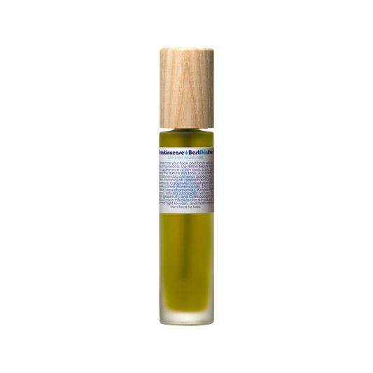 A small, cylindrical bottle containing a greenish-yellow cleanser, fitted with a wooden cap. The label features detailed information in multiple lines about "Best Skin Ever Cleanser- Frankincense" by Living Libations, suggesting its use as an acne redness soothing cleanser, exfoliator, and moisturizer.