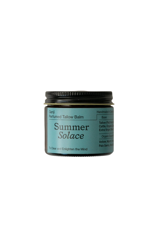 A jar of Genji Perfumed Balm - Regenerative Tallow™ by Summer Solace Tallow is displayed against a black background. The jar has a blue label with black text detailing the balm's ingredients, handmade origin, and promise to "clear and enlighten the mind." This moisturizing balm features a subtle woodsy scent perfect for aromatherapy.