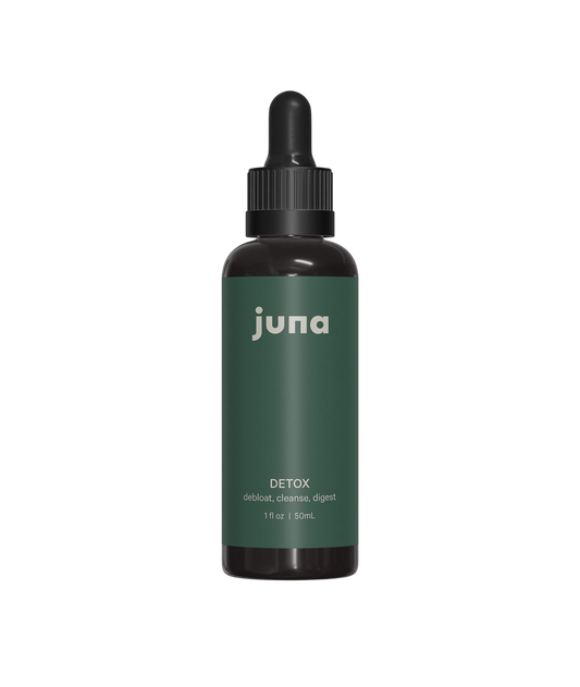 Product Description: A small dark glass bottle with a dropper cap featuring a green label. The label reads "Juna" at the top, followed by "Chlorophyll Detox Drops," with the description "debloat, cleanse, liver detoxification, healthy digestion" beneath. The bottle is 1 fl oz / 30 ml. The background is black.