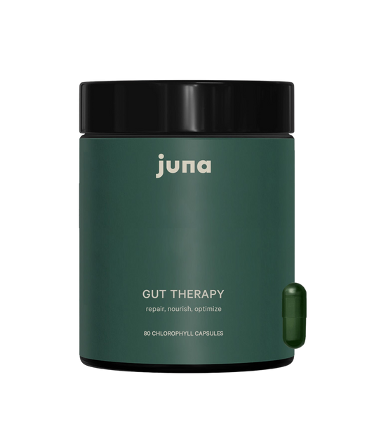 A dark green container of Juna Gut Therapy Supplement with a black lid is shown. The label reads "repair, nourish, optimize" and contains 80 chlorophyll capsules to support gut health. A single green capsule is positioned beside the container.