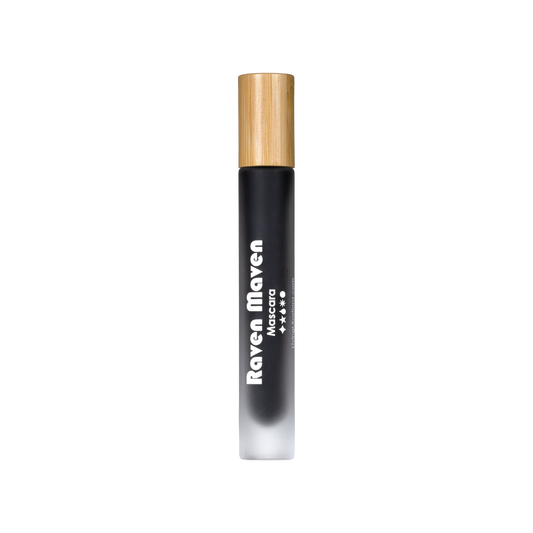 A sleek black tube of Raven Maven Mascara by Living Libations, adorned with a light brown wooden cap, is shown against a plain white background. Infused with natural volume-boosting waxes, the product name is displayed in white text vertically along the tube.