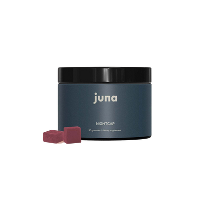 A black jar labeled "Juna" with "Nightcap Sleep Gummies" written beneath it. The jar contains 30 gummies as a dietary supplement designed for restorative sleep. Two red gummies are placed in front of the jar against a black background.