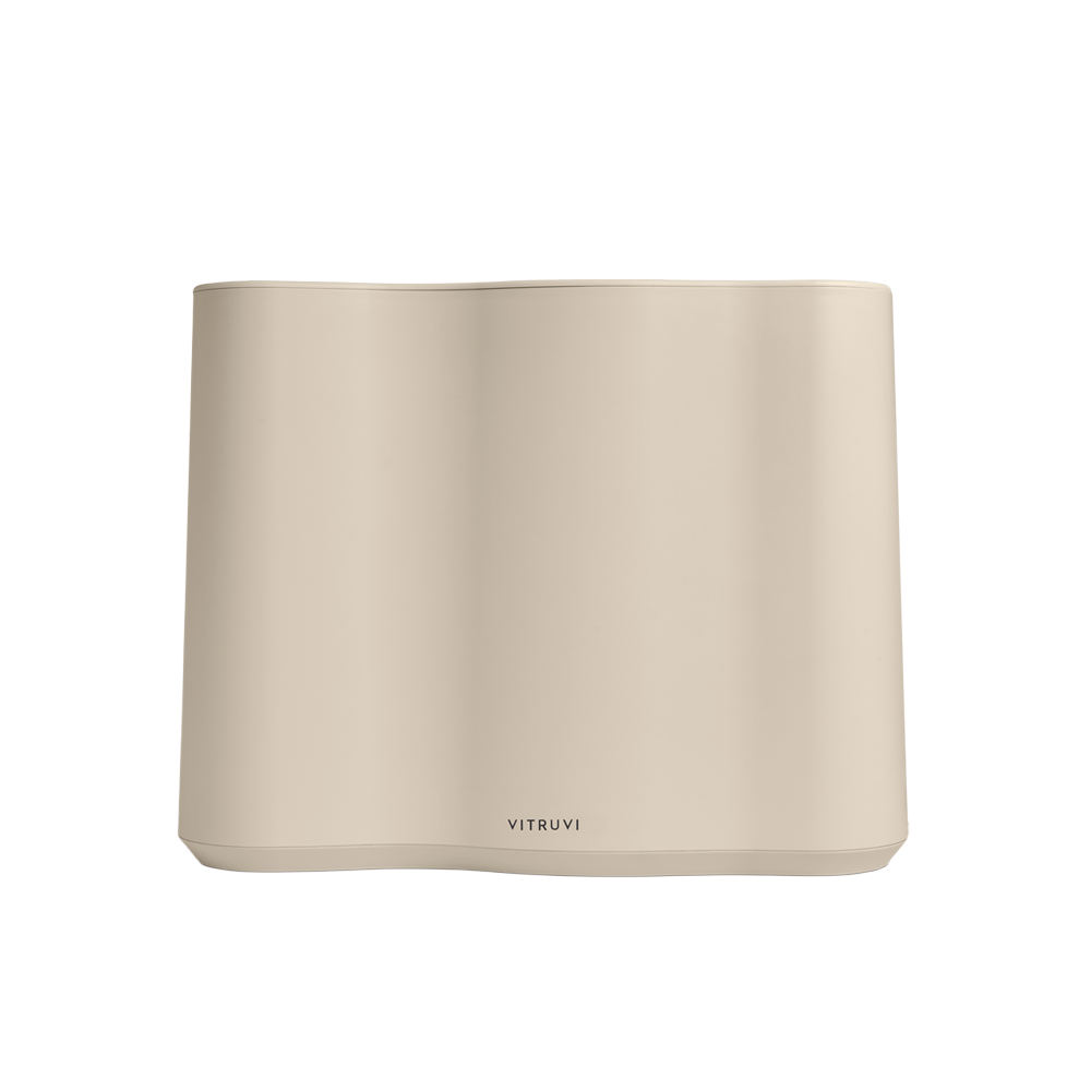 The Cloud Humidifier by Vitruvi is a minimalistic and modern essential oil diffuser, boasting a sleek beige rectangular design with rounded edges and smooth surfaces. The branding "Vitruvi" is prominently displayed at the bottom center of the front face. This diffuser uses ultrasonic technology for whisper-quiet operation.