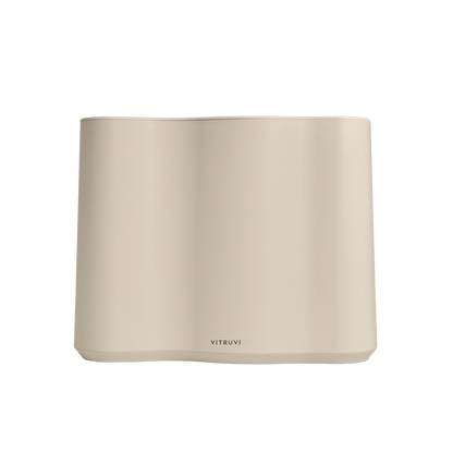 The Cloud Humidifier by Vitruvi is a minimalistic and modern essential oil diffuser, boasting a sleek beige rectangular design with rounded edges and smooth surfaces. The branding "Vitruvi" is prominently displayed at the bottom center of the front face. This diffuser uses ultrasonic technology for whisper-quiet operation.