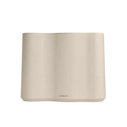 The Vitruvi Cloud Humidifier, a beige rectangular diffuser with smooth surfaces and subtly curved edges, has the brand name elegantly inscribed near the bottom center. It utilizes ultrasonic technology and provides adjustable mist levels for a personalized aromatherapy experience.