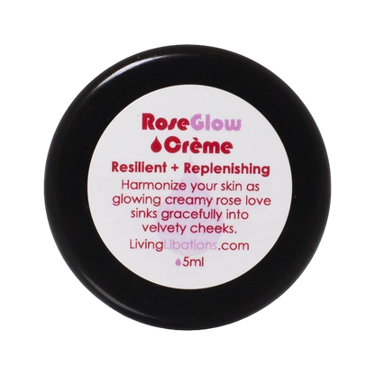 A small, round black jar with a white label on the lid. The label reads "Living Libations - Rose Glow Crème - Resilient + Replenishing." Harmonize your skin as this botanical moisturizer sinks gracefully into velvety cheeks. LivingLibations.com - 5ml.