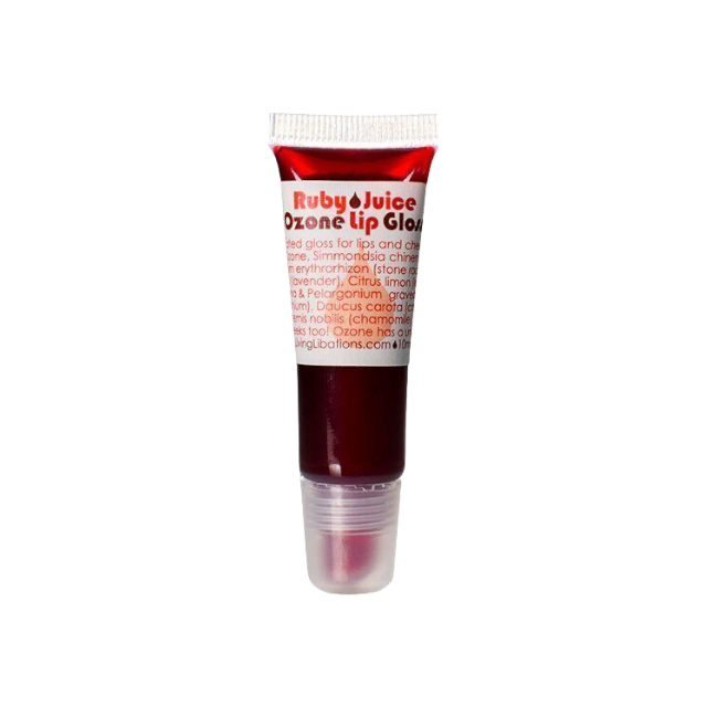 A compact, transparent plastic tube with a red cap that holds the Ruby Juice Ozone Lip Gloss by Living Libations. Filled with deep red, naturally pigmented gloss, the tube features printed text outlining its ingredients and branding. The product is shown against a white background.