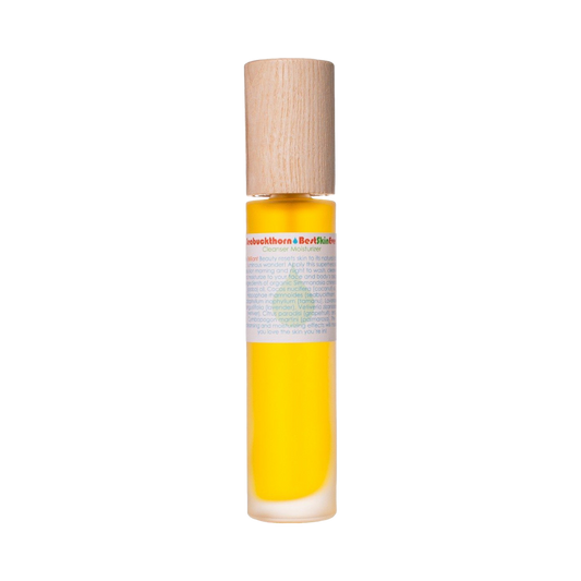 A transparent cylindrical bottle with a wooden cap, filled with a yellow liquid that is likely organic oils or serum. The bottle features a white label with text and a green emblem highlighting Seabuckthorn. It contains the Best Skin Ever Cleanser - Seabuckthorn by Living Libations.