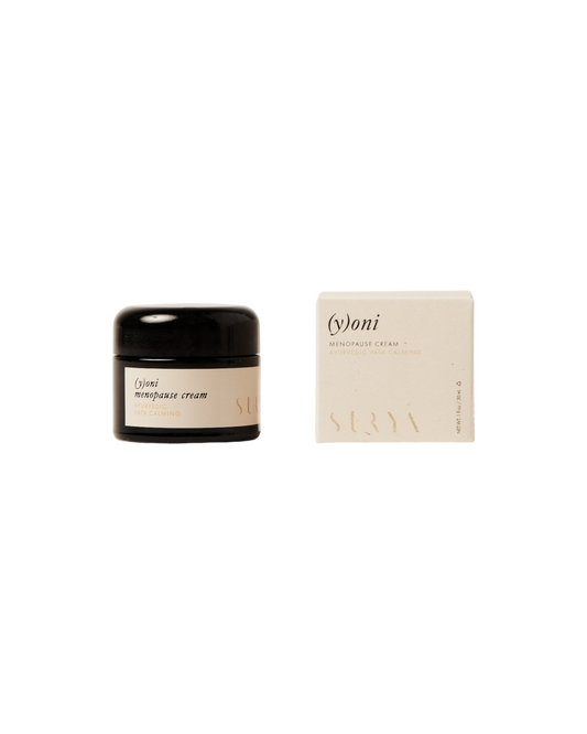 A product image showcasing a jar and a box of Surya (y)oni Menopause Cream, an intimate skin care solution infused with Ayurvedic botanicals. The jar features a black lid and beige label, while the minimalist box is also beige. Labeled "For Cooling & Moisturizing," the net weight is 1 oz.