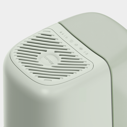 Close-up of a sleek, modern Bedside Humidifier 2.0 in light green. It features a slotted vent and icons for settings near the top, with "Canopy" branding indicating it's Fulfilled by Canopy visible near the vent.